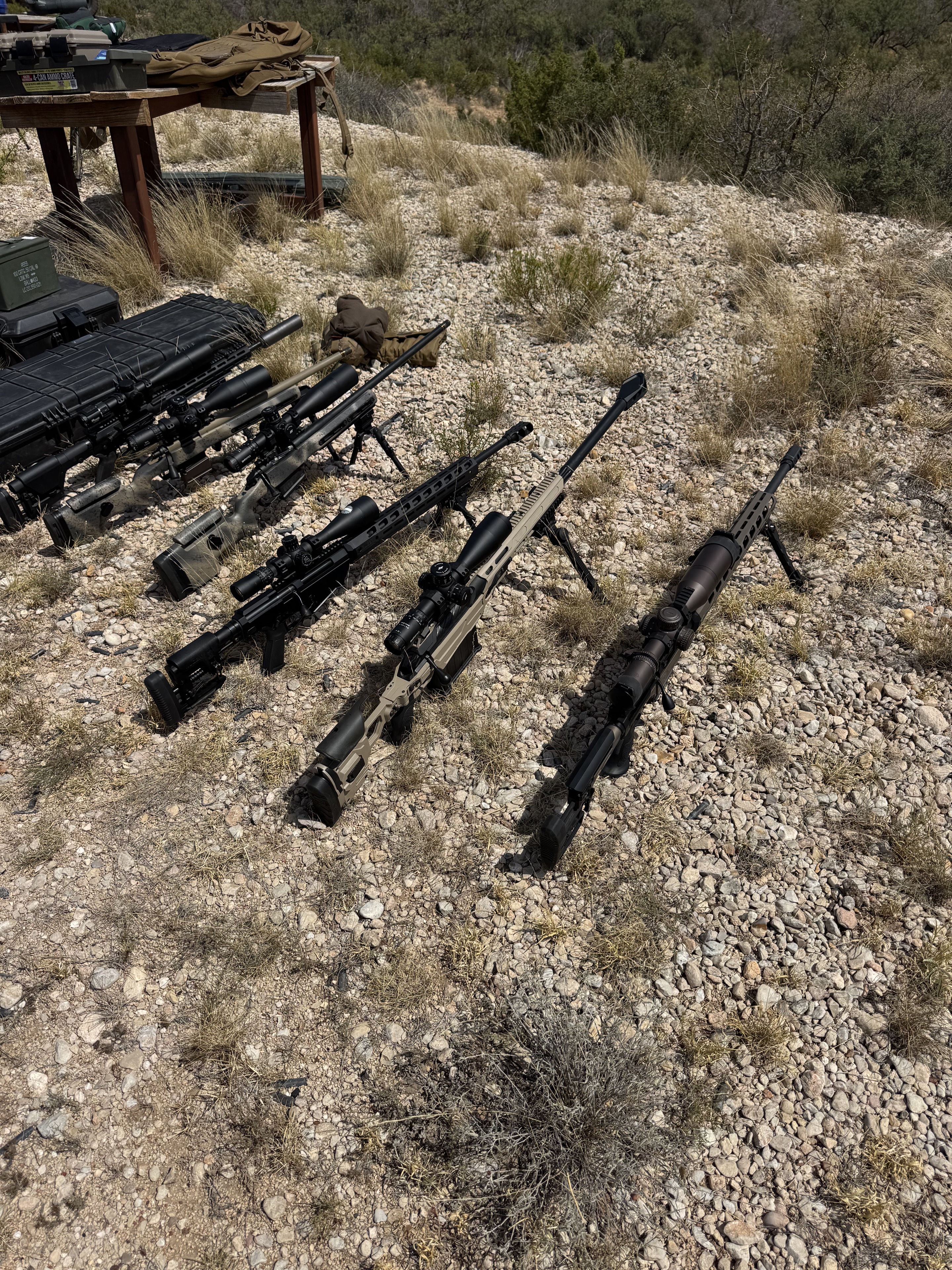 Precision rifles staged safely together at the outdoor range