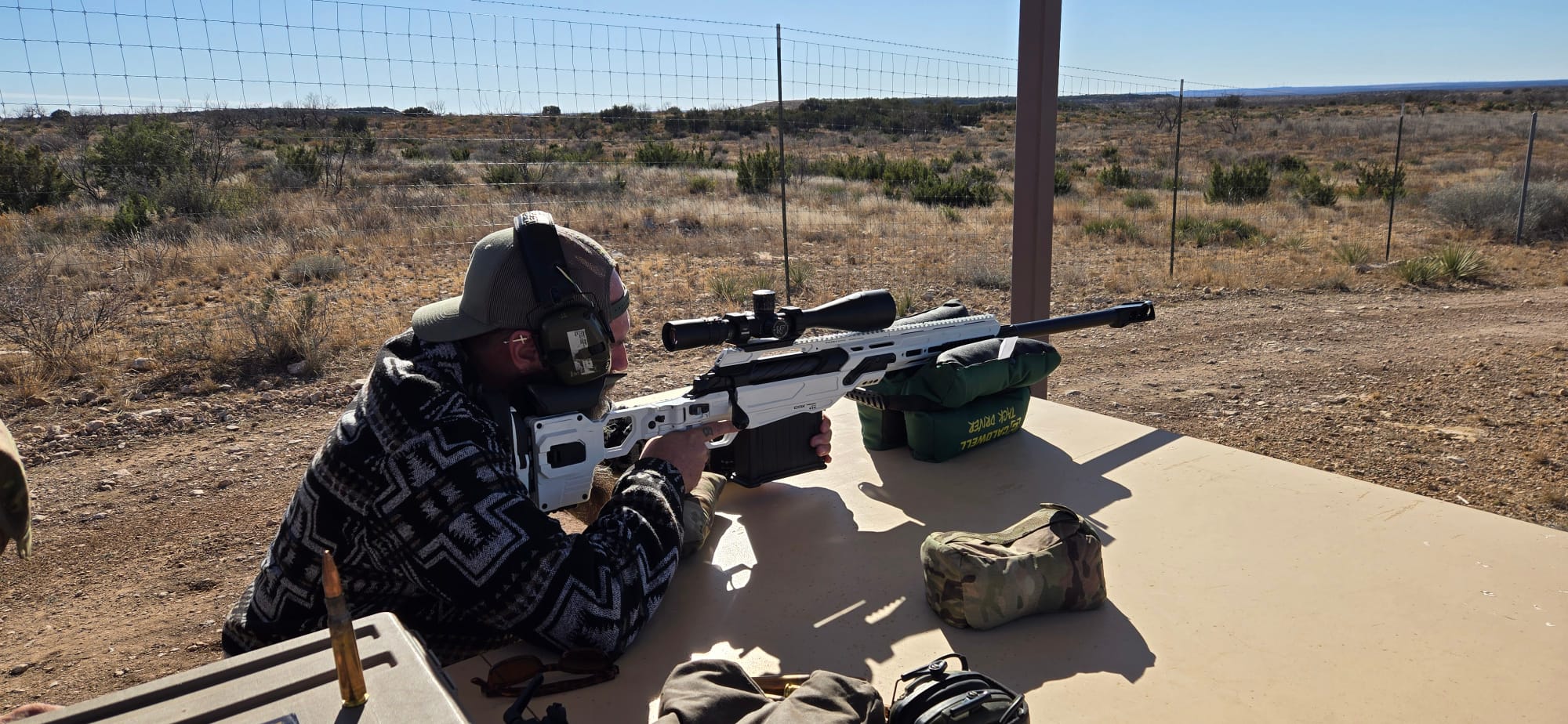 A veteran aiming a white precision rifle from the bench
